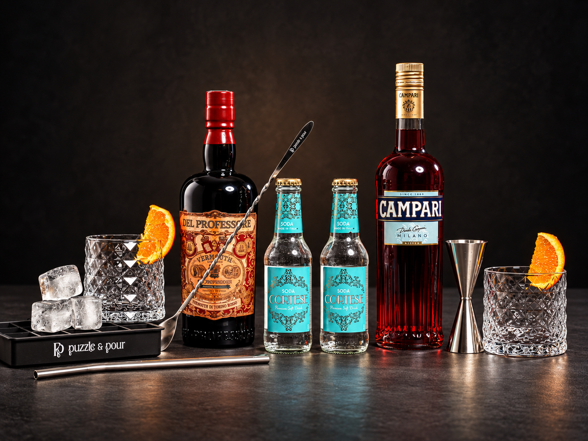 Americano Premium Box Puzzle & Pour con Campari, Vermouth Rosso Del Professore, Soda Cortese, due bicchieri Old Fashioned e attrezzatura da bartender. Kit cocktail completo e idea regalo originale per gli amanti dei cocktail e dell'aperitivo italiano.