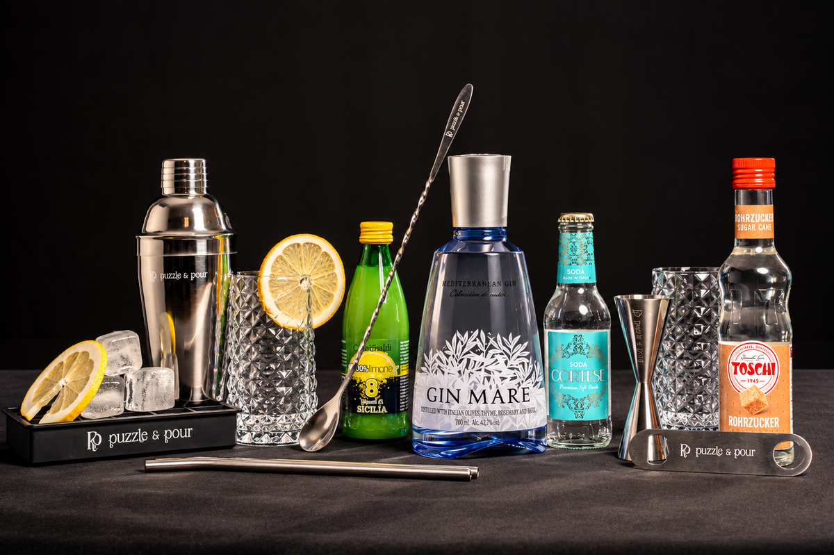 Gin Fizz Mare Premium Box di Puzzle & Pour con Gin Mare Mediterranean Gin, Soda Cortese, succo di limone, sciroppo Toschi, due bicchieri e attrezzatura professionale da bartender. Kit cocktail completo e idea regalo originale per gli amanti del gin, perfetto per compleanni, Natale e occasioni speciali.f
