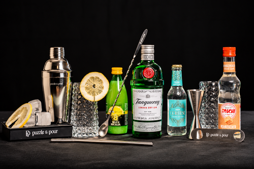 Tanqueray Gin Fizz Premium Box di Puzzle & Pour con Tanqueray London Dry Gin, Soda Cortese, succo di limone, sciroppo Toschi, due bicchieri e attrezzatura professionale da bartender. Kit cocktail completo e idea regalo originale per gli amanti del gin e della mixology.